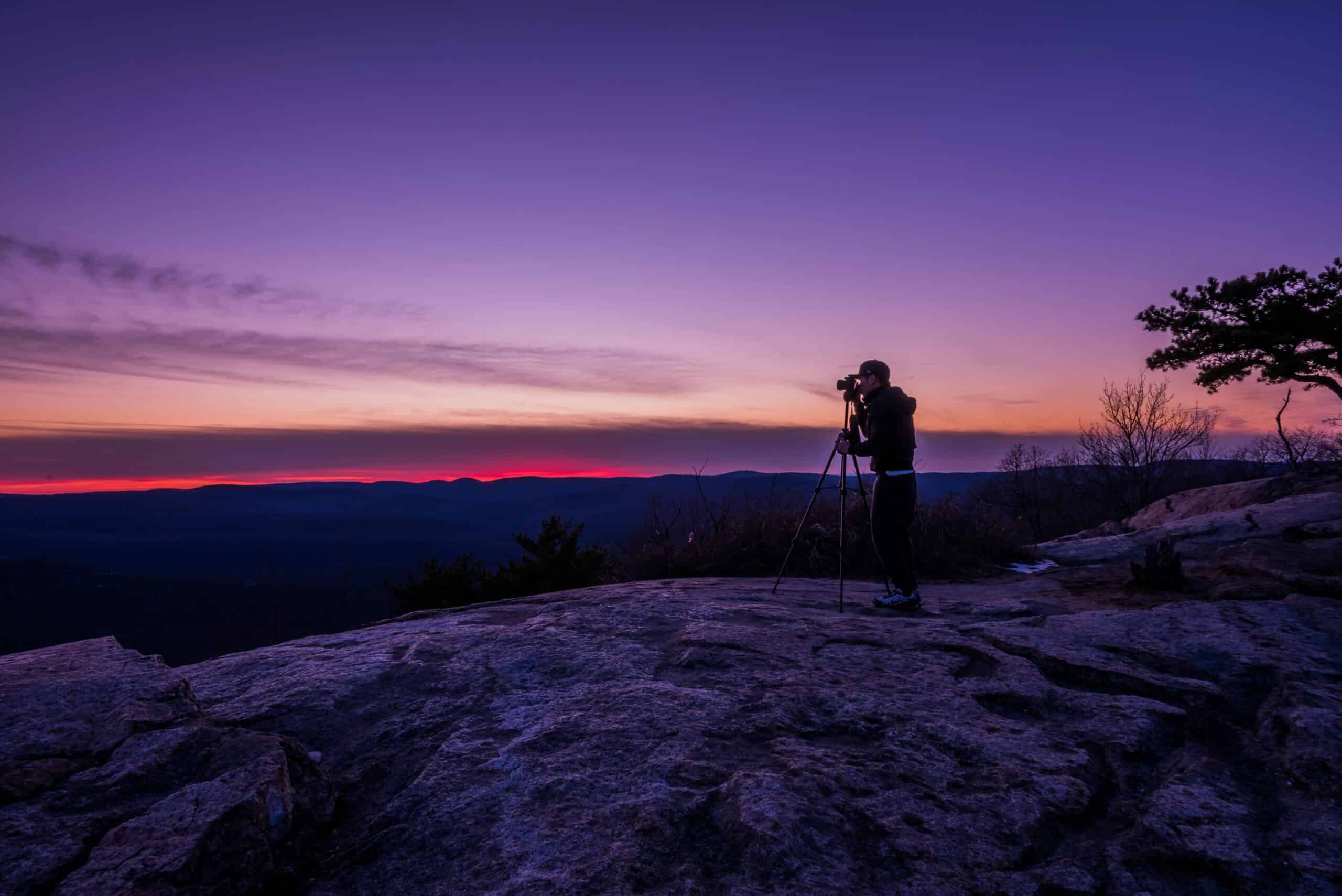 Photographer using a tripod to capture panorama outdoors